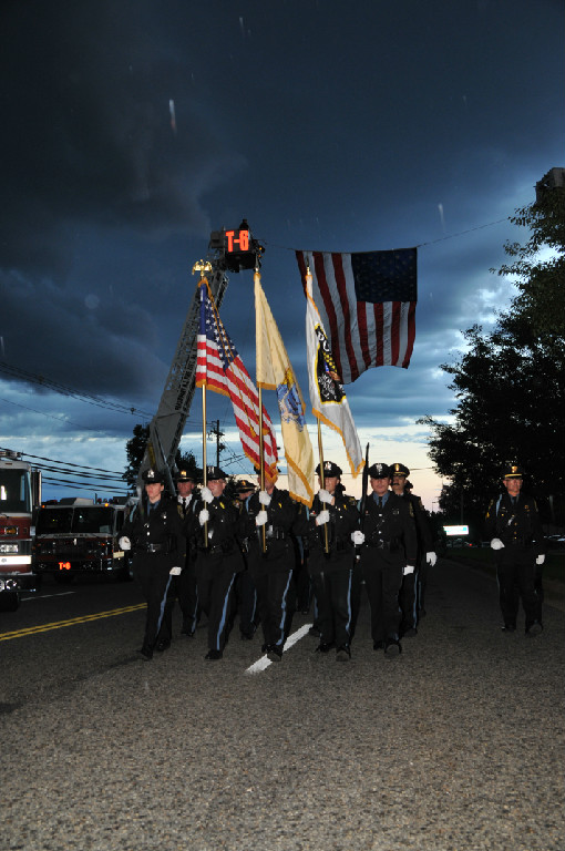 Honor Guard marching with flags down the street.